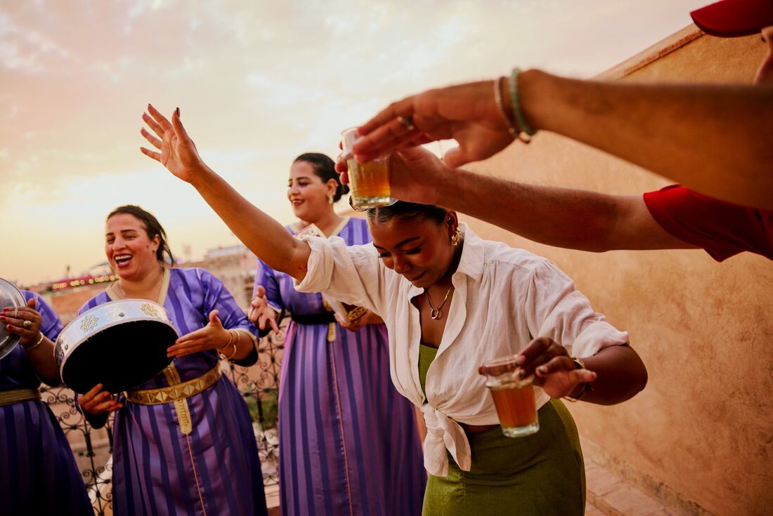 Traveller dancing to locals playing live music, Marrakech, Morocco