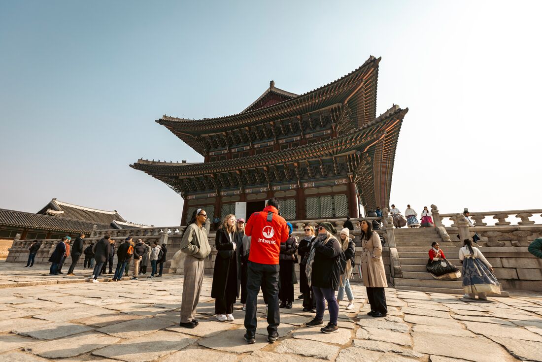Leader giving a talk to group on the grounds of Gyeongbokgung Palace in South Korea