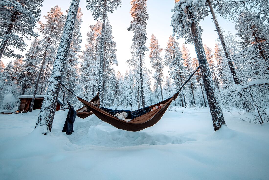 Intrepid traveller in a cozy hammock cocooning in Finland's forests