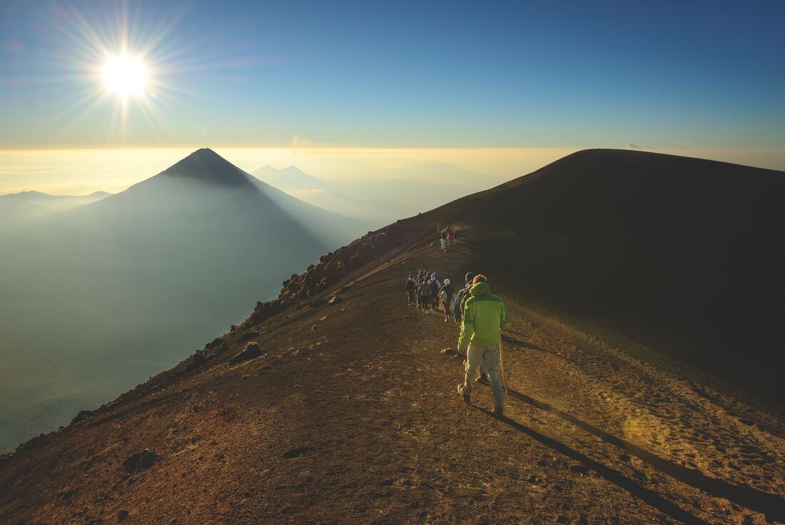 Intrepid travellers approaching Acatenango's peak near Antigua in Guatemala with Fuego beyond