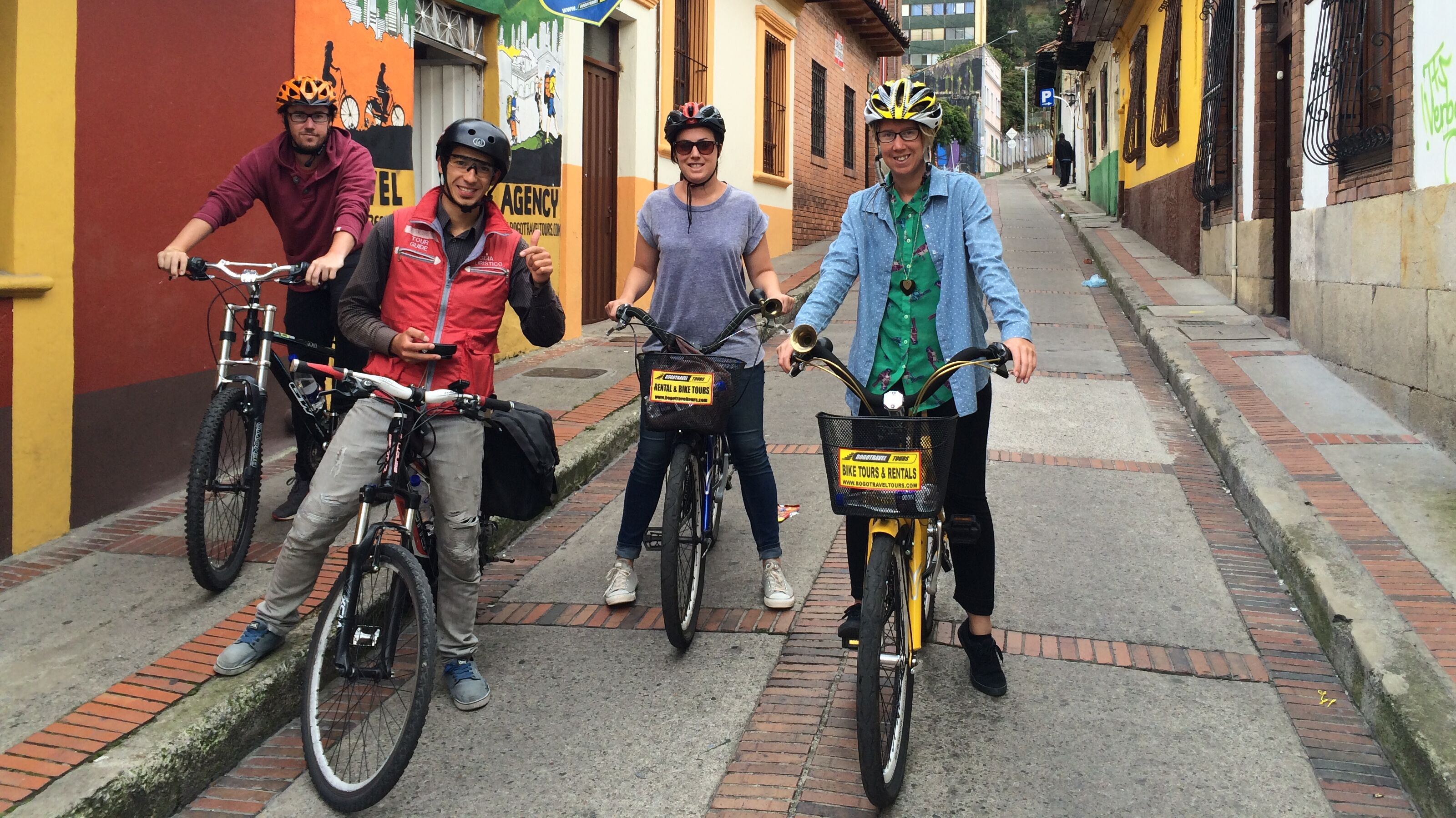 Four cyclists smiling on a street in Columbia