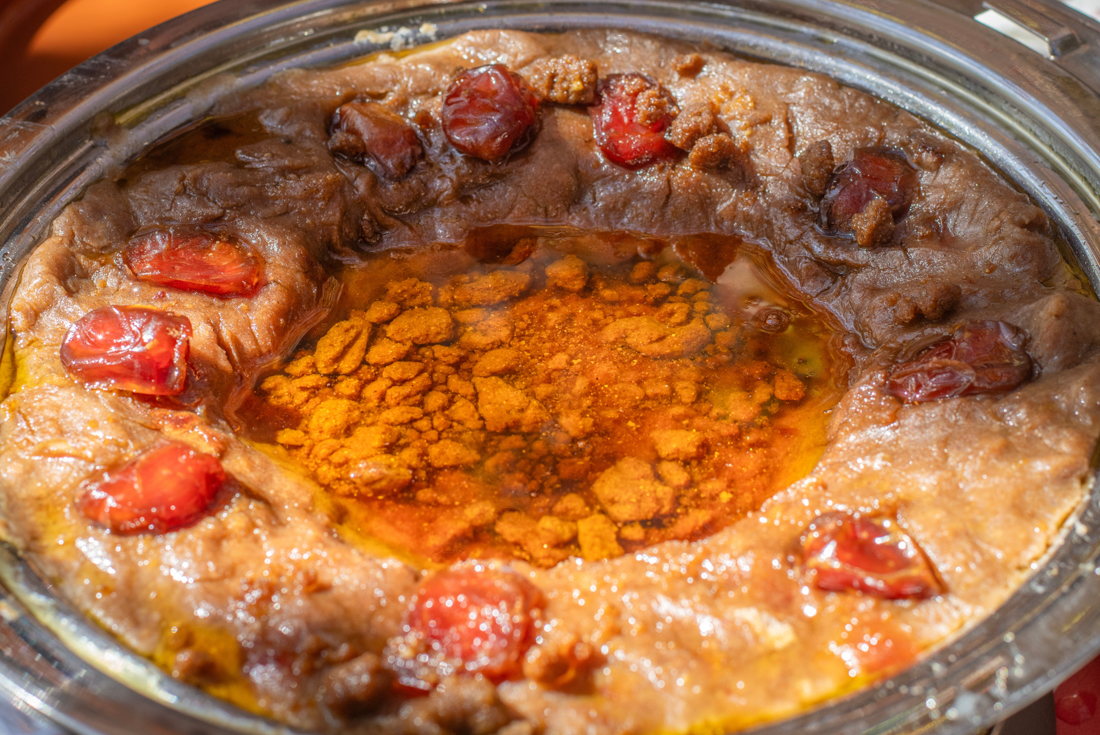 Freshly made areeka - liquid dough fried on a griddle with ghee and honey filled in the center and dates around the edges