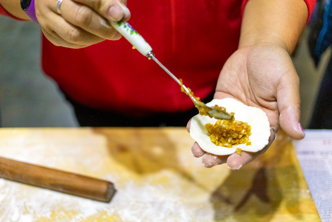Close shot of Intrepid leader holding an open dumpling with fresh filling in China