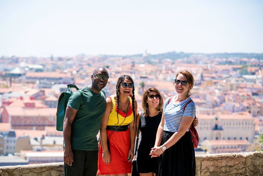 Group of Intrepid travellers laughing with city view in Lisbon, Portugal