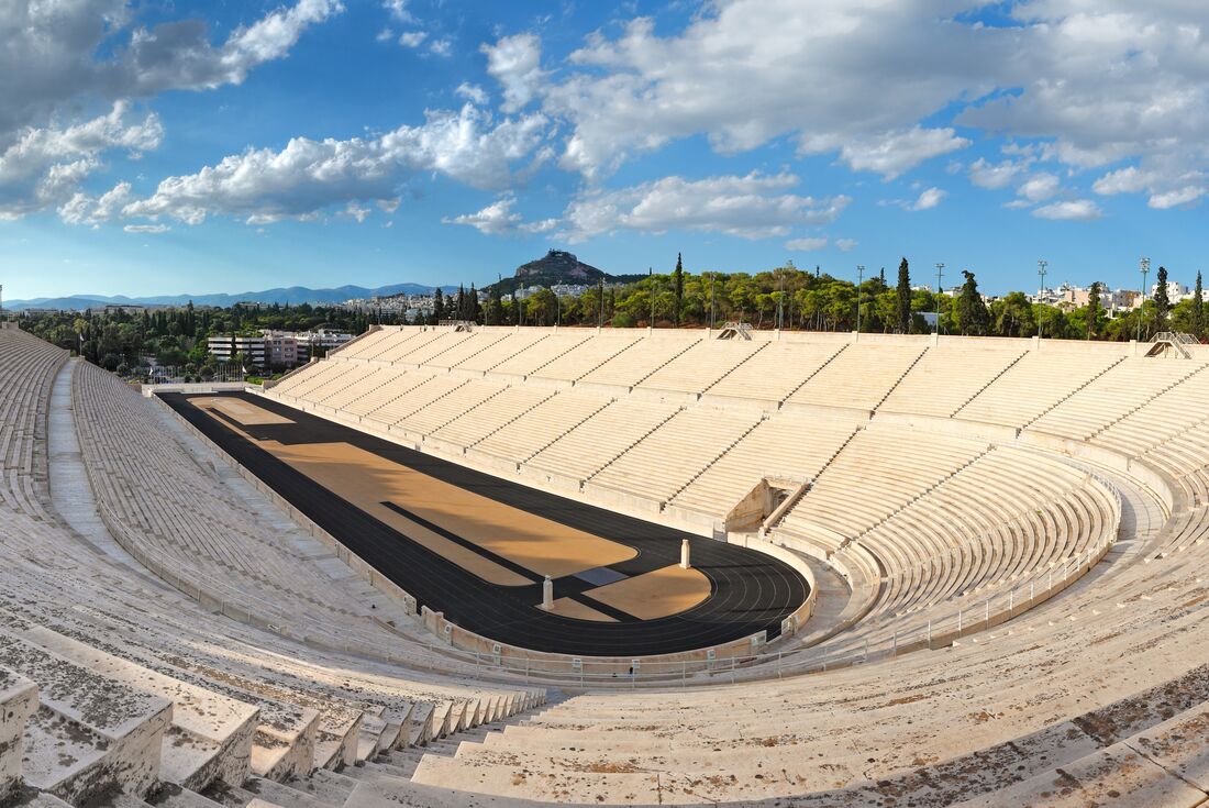 Wide view of empty Panathenaic Stadium on sunny day with fluffy white clouds, Athen, Greece