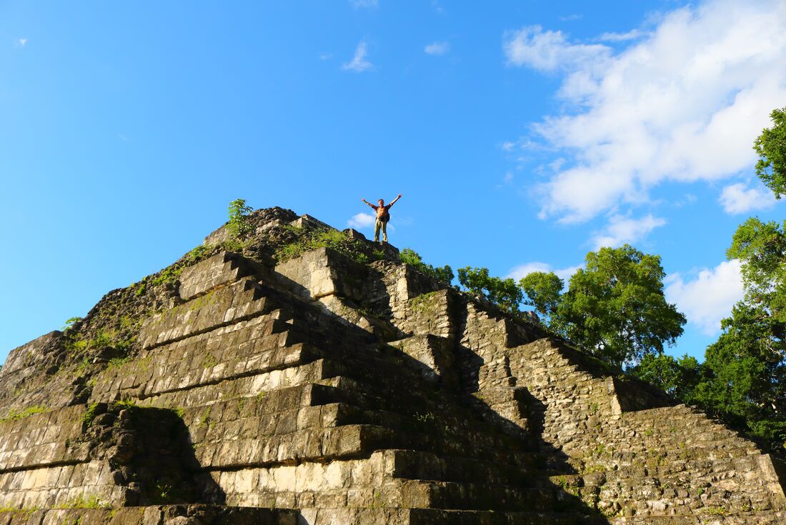 Intrepid traveller celebrates atop the Mayan pyramid of Yaxha Nakum Naranjo National Park