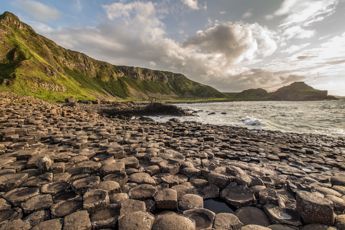 Travellers in the distance explore the Giants Causeway on the northern shore of Ireland 