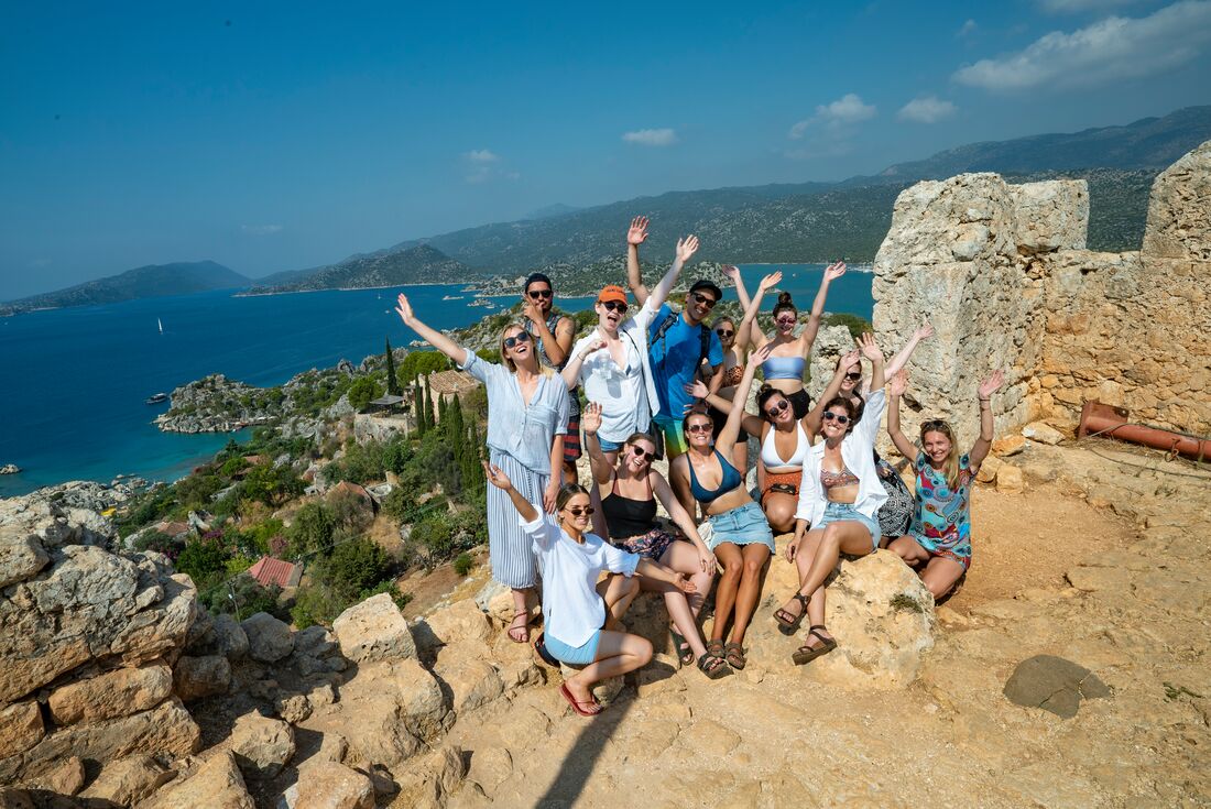Intrepid Travel group posing for a photo on the coast of Antalya, Turkey