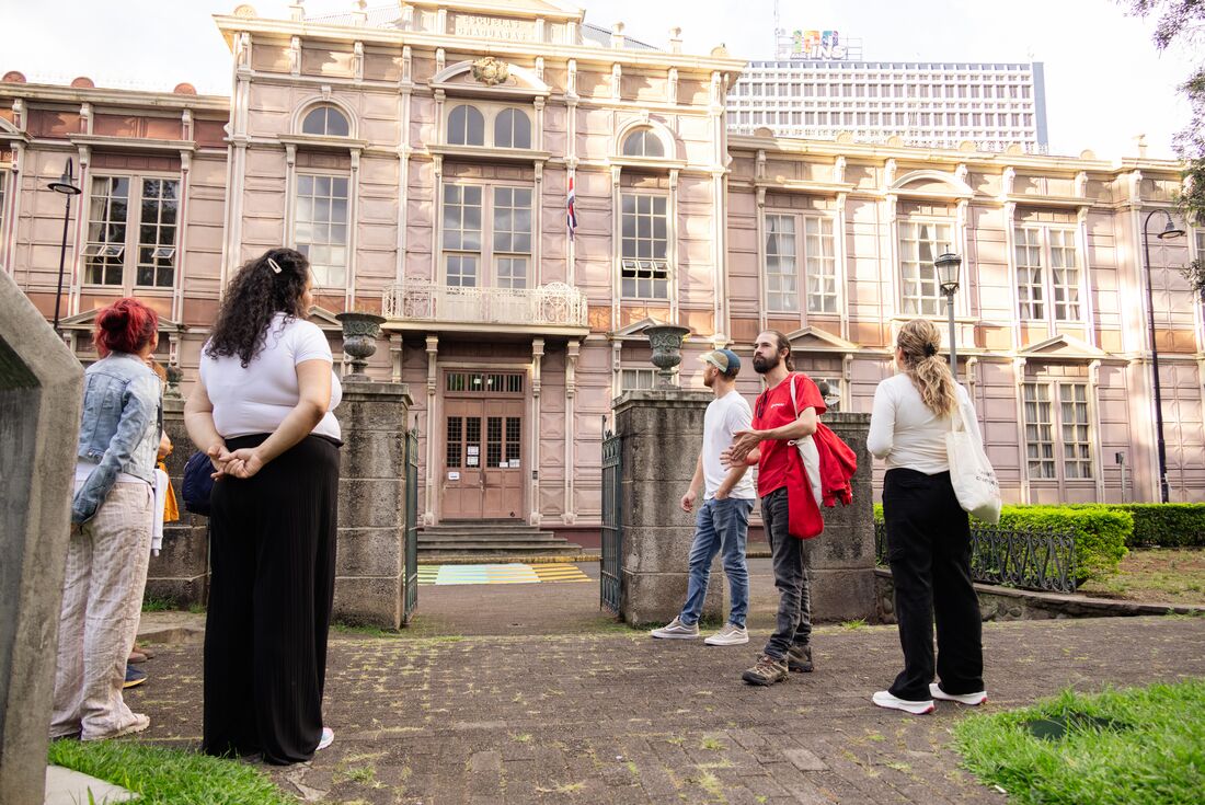 Leader talking to travellers in front of Edificio Metalico University in San Jose, Costa Rica