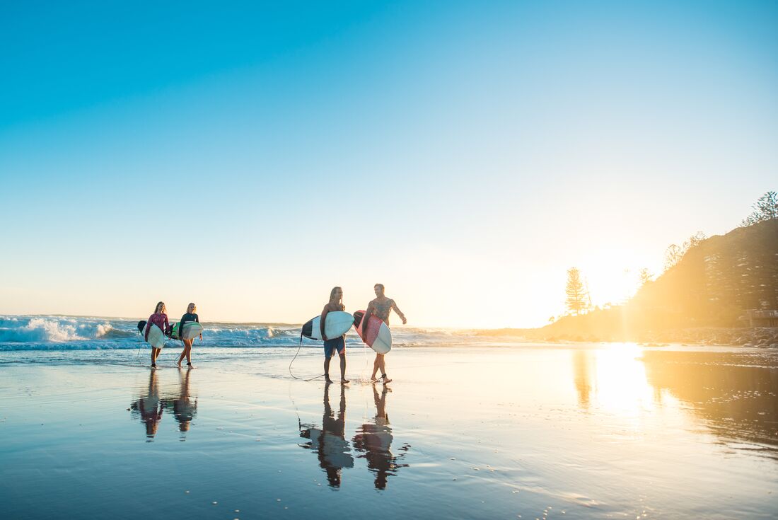18 to 35 year old Travellers come in from a morning surf on the NSW coast at sunrise