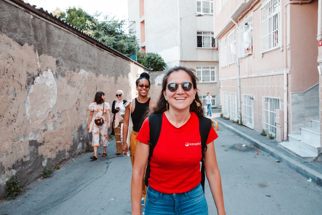 Intrepid leader smiles leading a group of travellers through the streets of Istanbul in Turkey