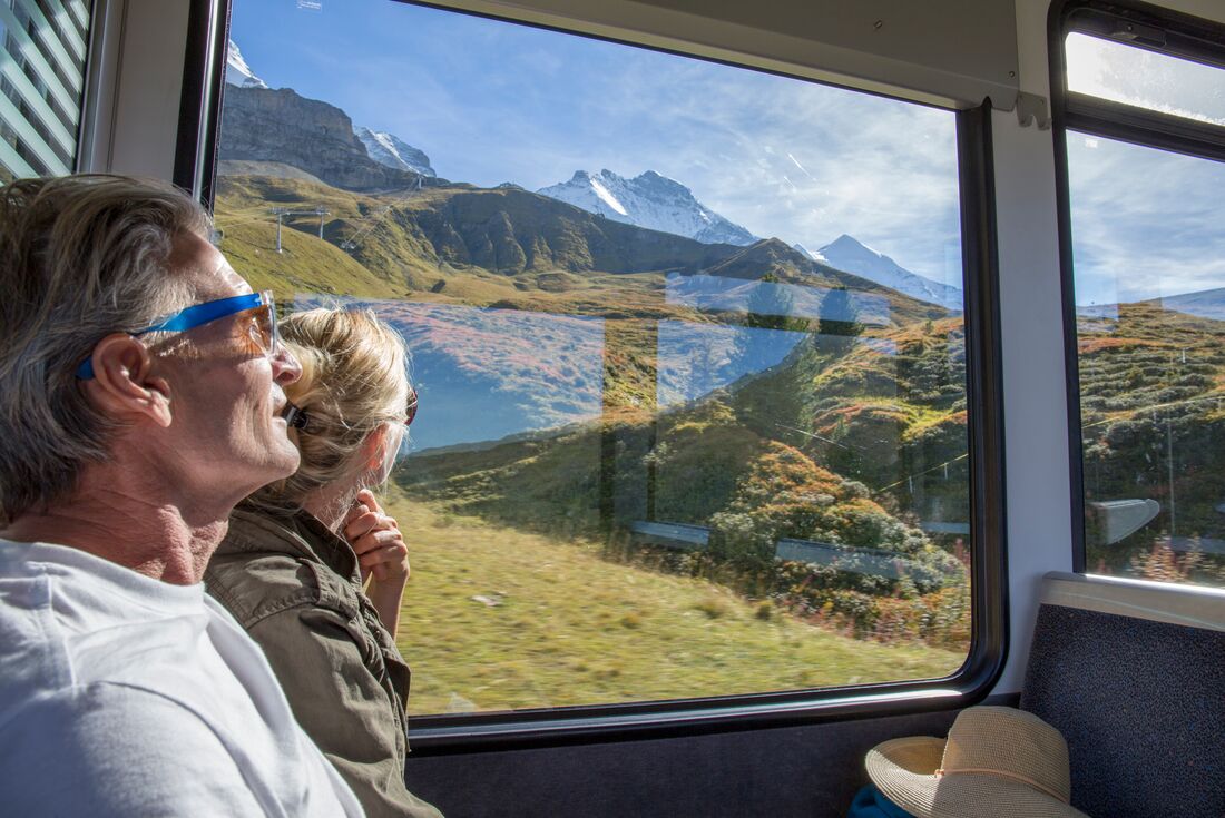 Older couple look up at mountain range in Switzerland