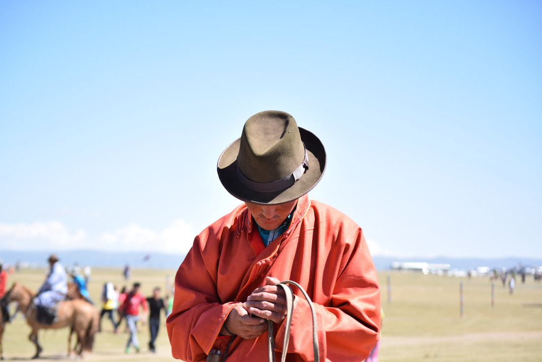 Intrepid Travel mongolia local texting on horse