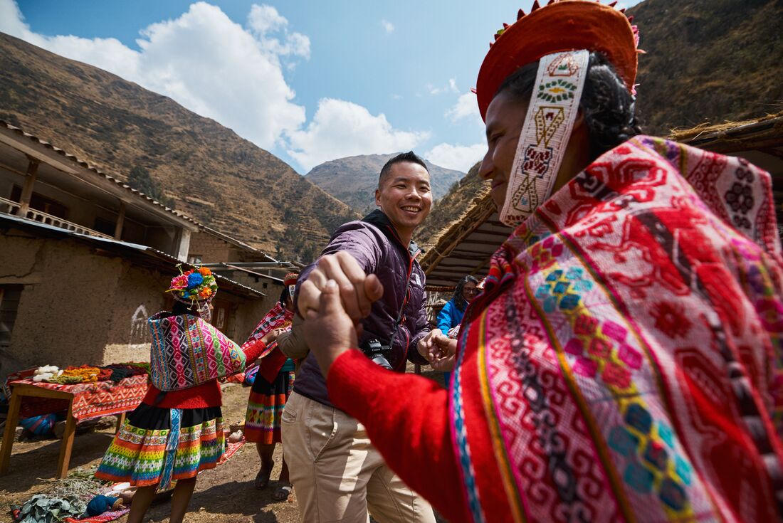 Intrepid traveller dancing with Huilloc community members in Peru Sacred Valley