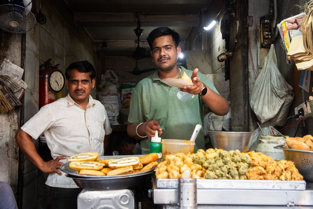 Street food vendor smiling as he offers food in Delhi, India