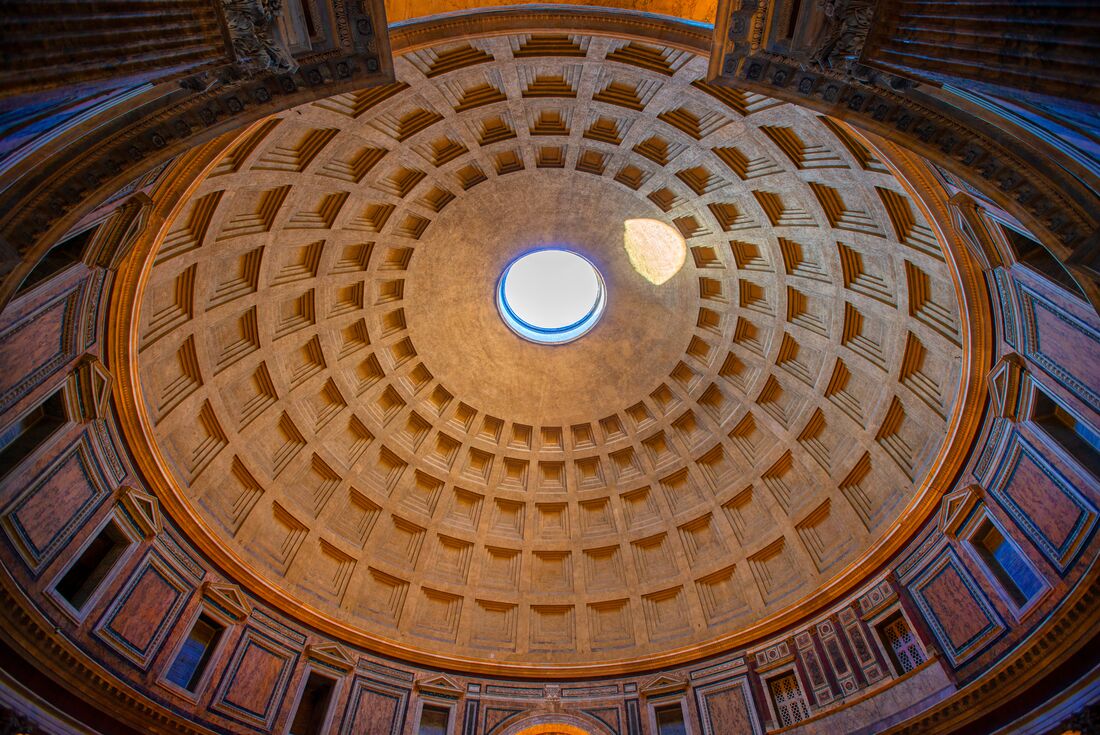 Wide shot looking up at the interior of the dome roof at the Pantheon in Rome, Italy with an orange hue being casted