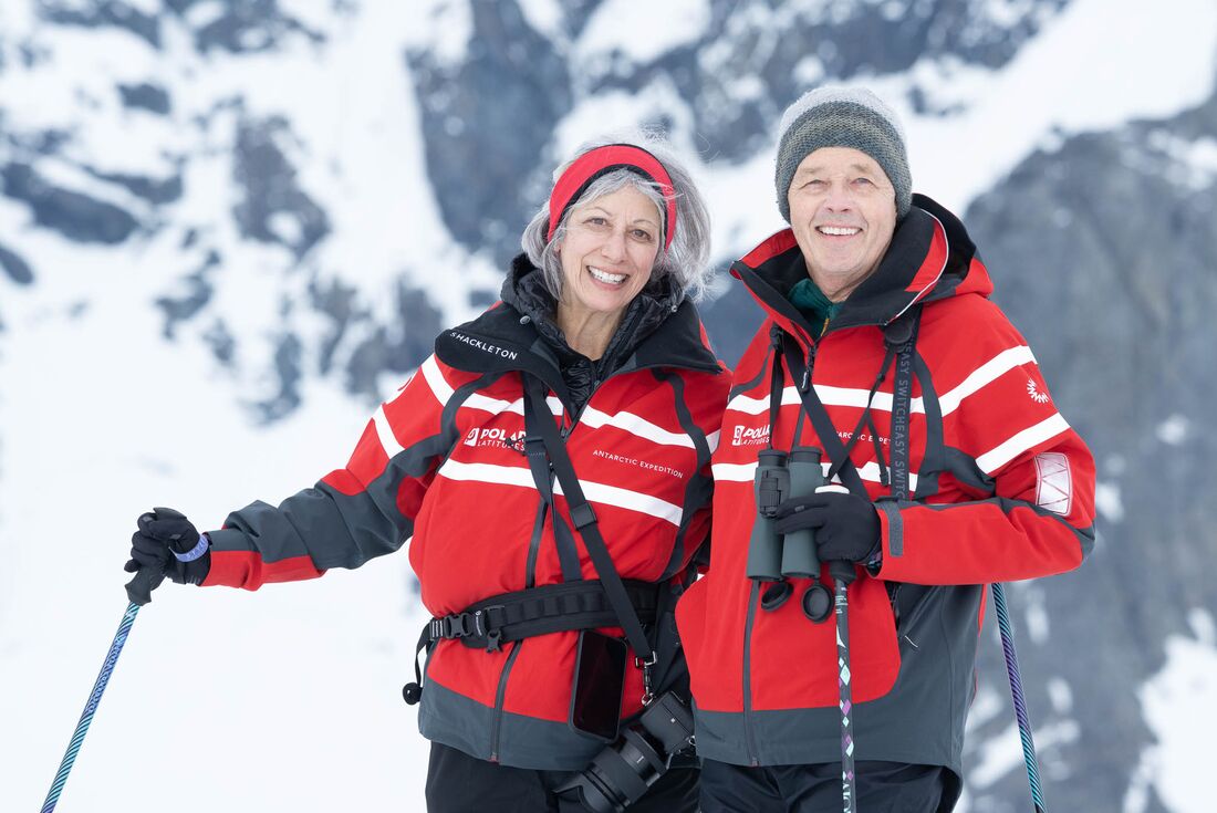 Travellers on a Danco Island hike smile at the camera in Antarctica
