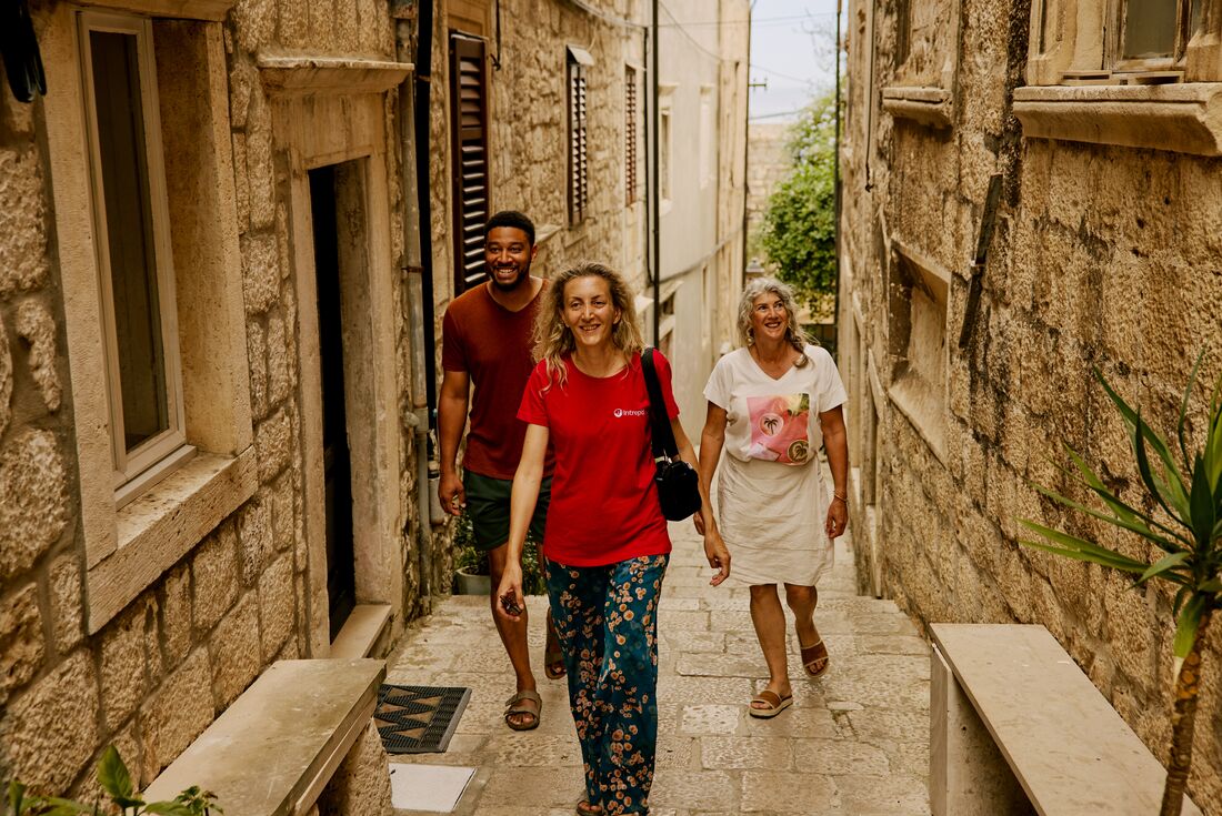 Leader walking with travellers in a small, cobblestone street in Korcula, Croatia
