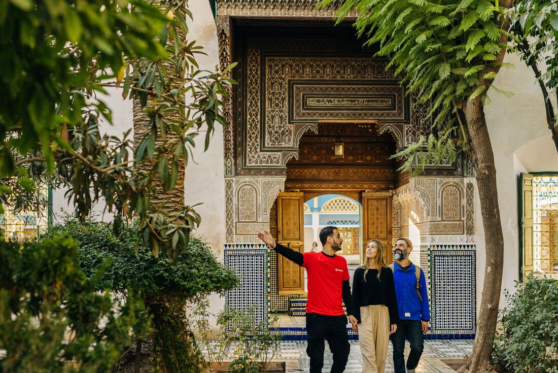 Group of Intrepid travellers and leader tour an ornate riad (internal garden) in Marrakech, Morocco