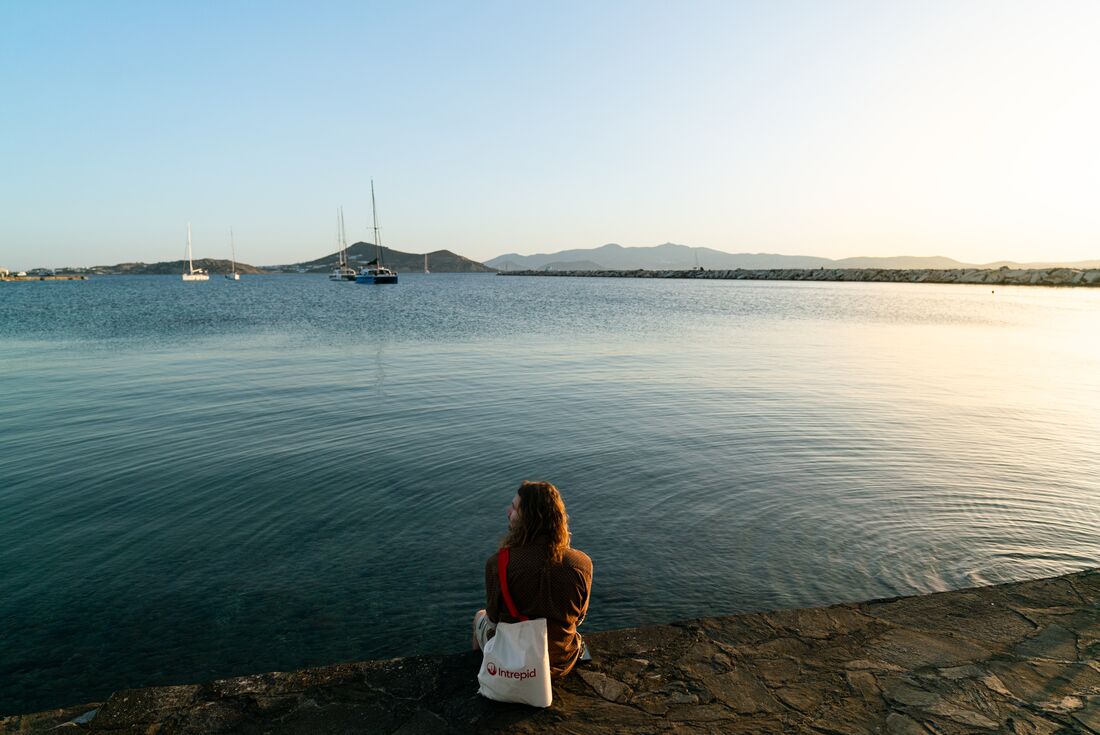 Intrepid traveller relaxing on rocky shore by the water on Naxos in Greece