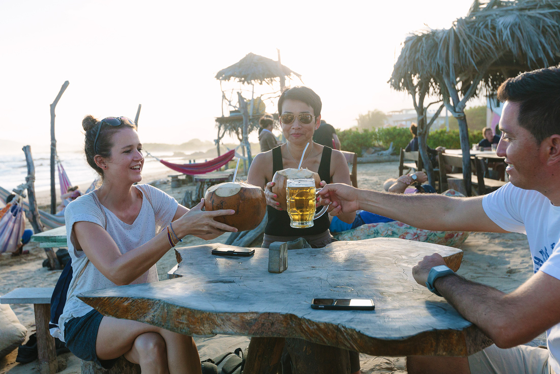 Travellers toast drinks on the beach, Galapagos Islands