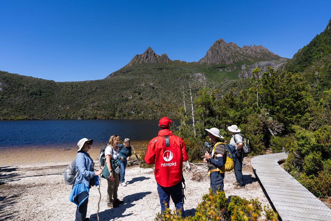Group standing on the shores of Lake St. Clair looking up Cradle Mountain in Tasmania