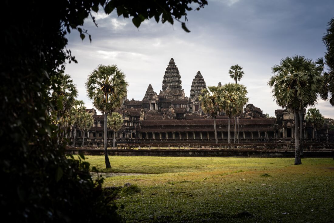 Watching sunrise emerge over Angkor Wat's prasat towers in the rainforests of Cambodia