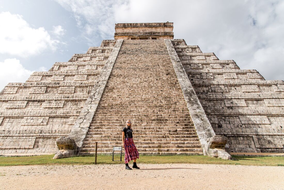 Traveller posing in front of El Castillo Pyramid at Chichen Itza, Mayan ruins in Mexica