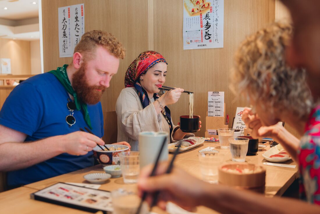 Travellers enjoy a sushi and noodle lunch in Tokyo restaurant