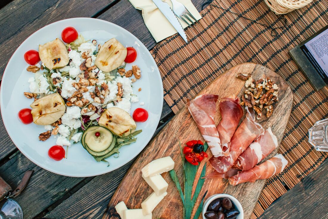 A top-down flatlay of mixed meats and picked vegetables for lunch in Ljubljana, Slovenia