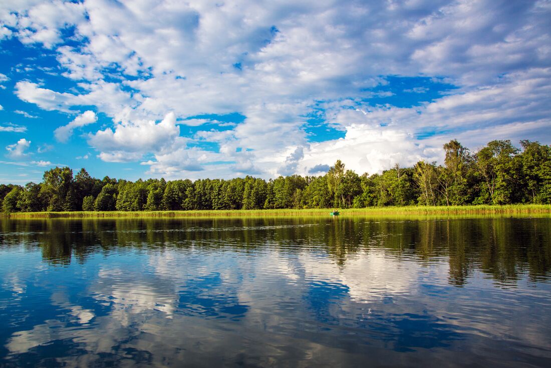 Boat with travellers canoeing on a lake in the scale of Aukstaitija National Park, Lithuania