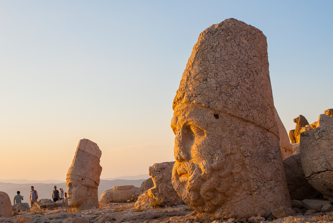 Ancient statue heads of kings and gods lit by the setting sun on the summit of Mount Nemrut in eastern Turkey