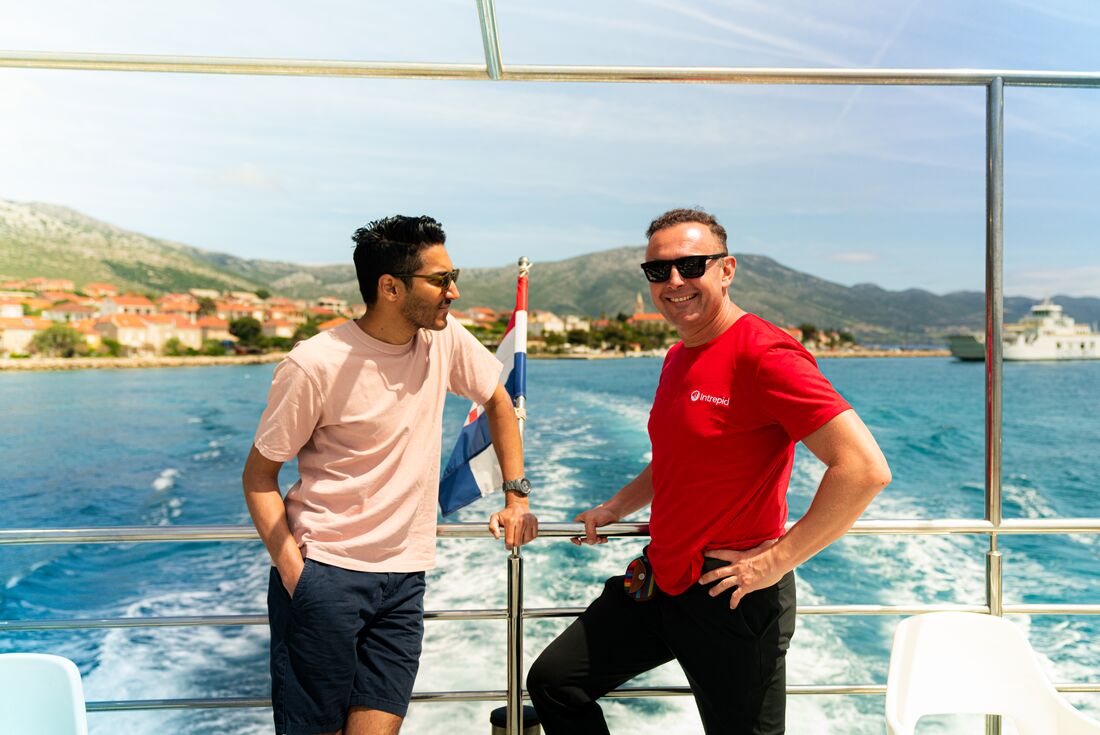 Intrepid leader talks to traveller on a sunny day ferry ride to Korcula in Croatia